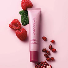 Load image into Gallery viewer, Moroccanoil berry pomegranate lip balm with raspberries and pomegranate seeds on a pink background